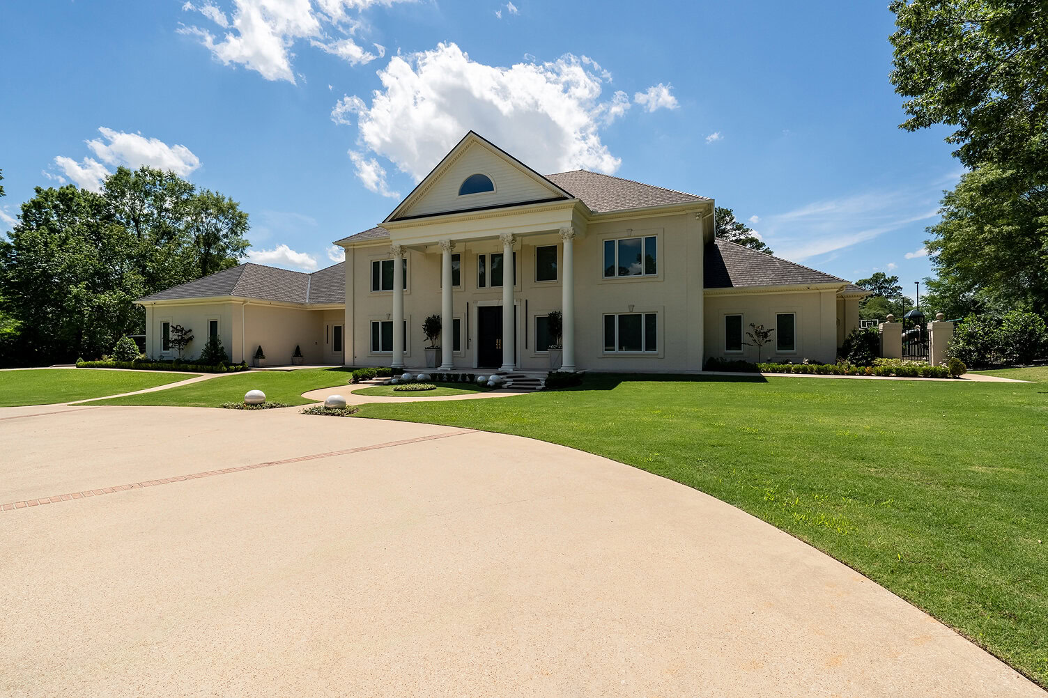 Beautiful large colonial house with white exterior and grand columns in The Thornwood.