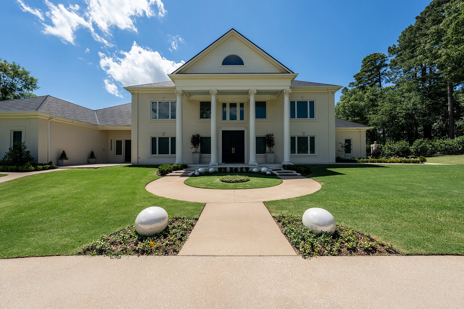 Stunning white mansion with grand entrance and lush green lawn in The Thornwood.