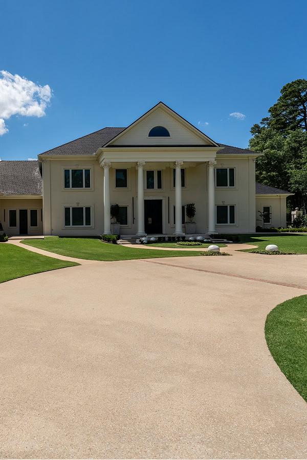Beautiful white colonial house with grand columns and manicured lawn in The Thornwood.