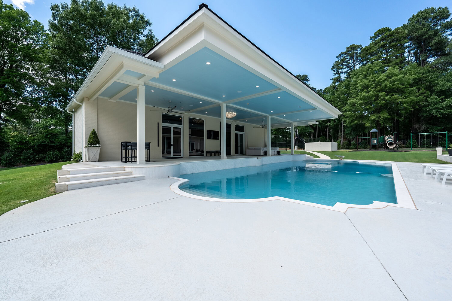 Contemporary pool house with a pool and outdoor seating area at The Thornwood.