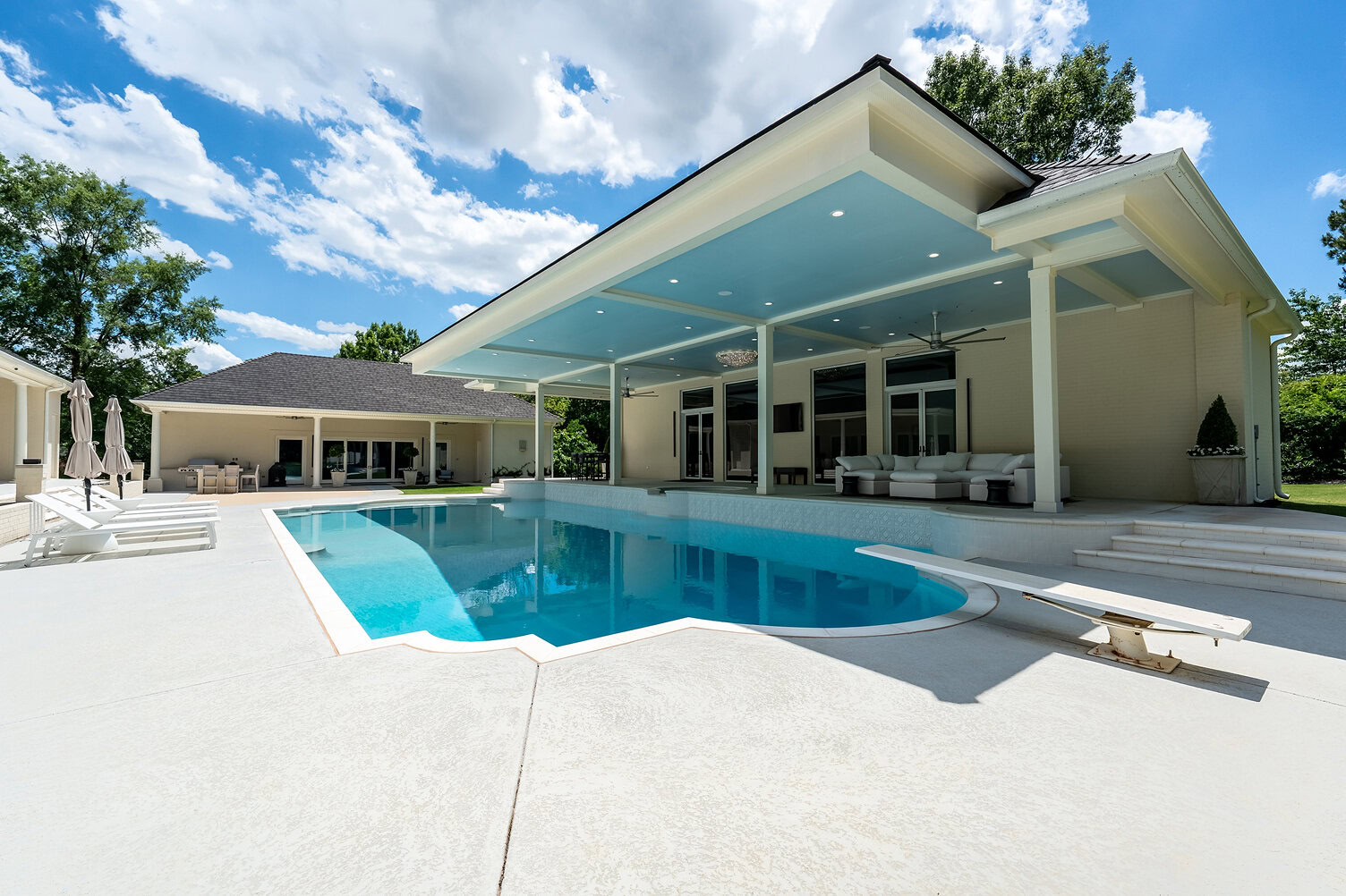 Modern house with a swimming pool and spacious patio area.