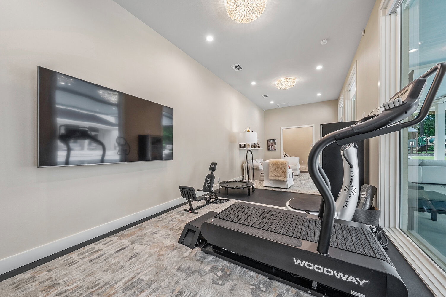 Home gym with treadmill, TV, and cozy seating at The Thornwood.