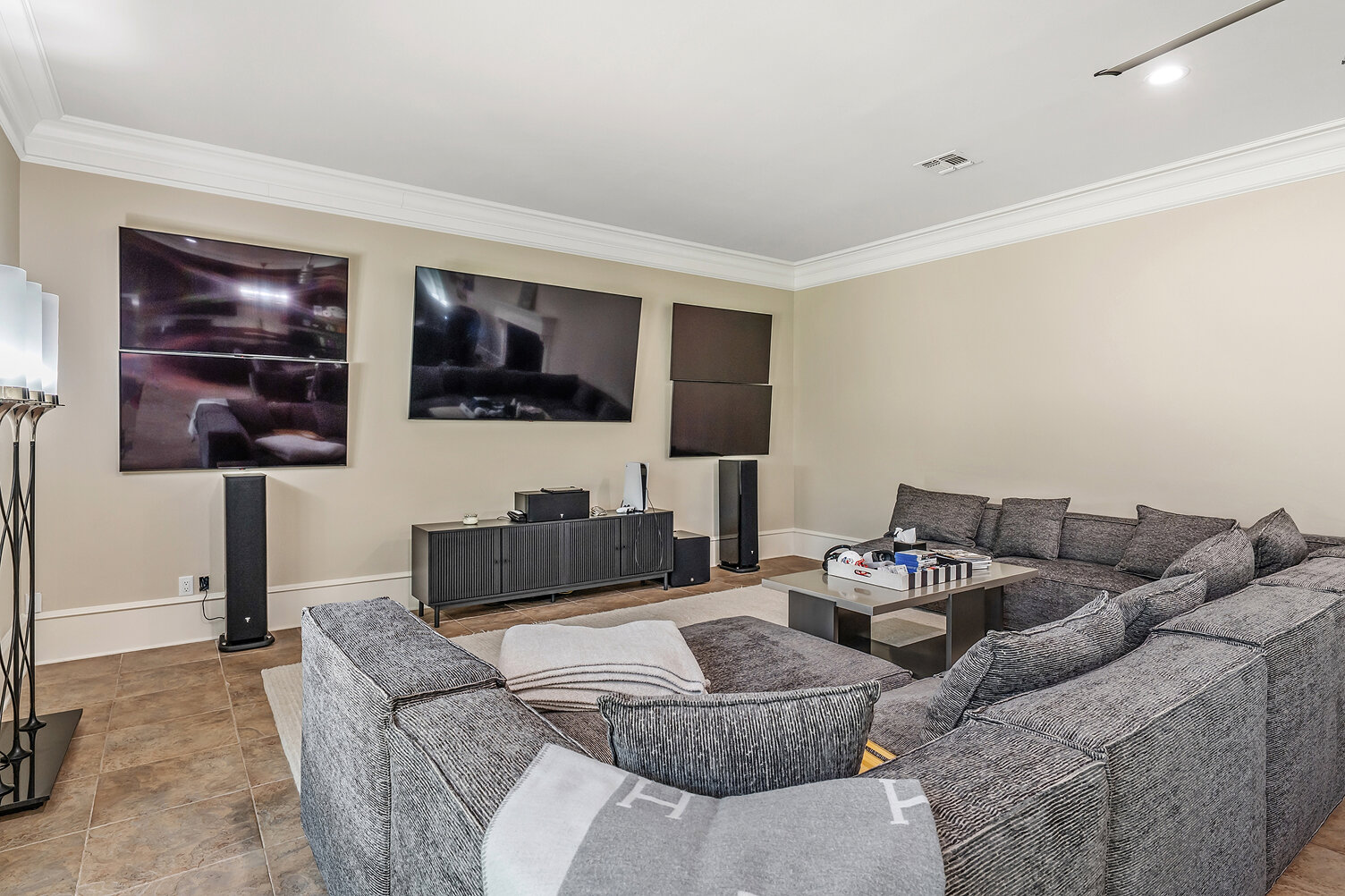 Modern home theater with large screens and surround sound system.