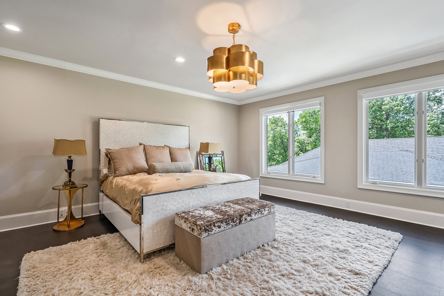 Spacious bedroom with large windows, modern decor, and cozy furnishings.