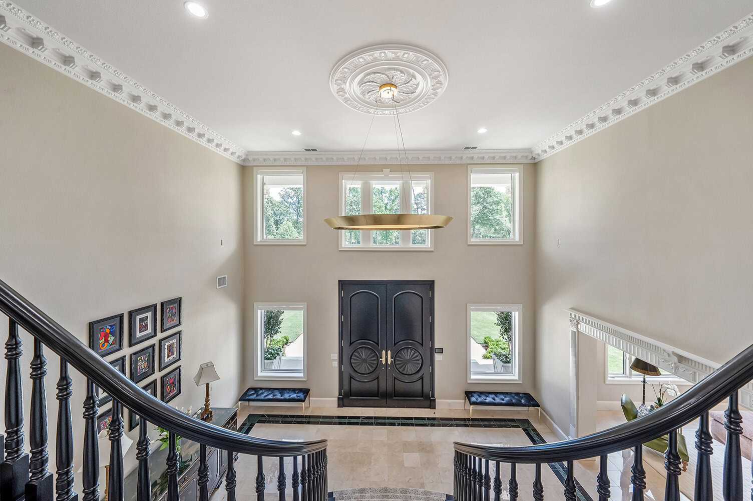 Spacious and stylish foyer with high ceilings and decorative molding.