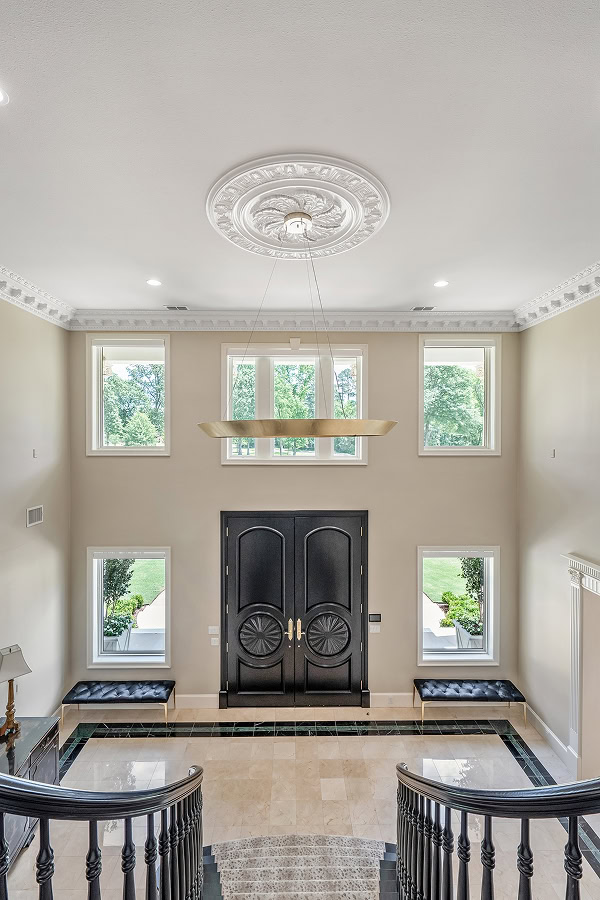 Bright foyer with black double doors and large windows.