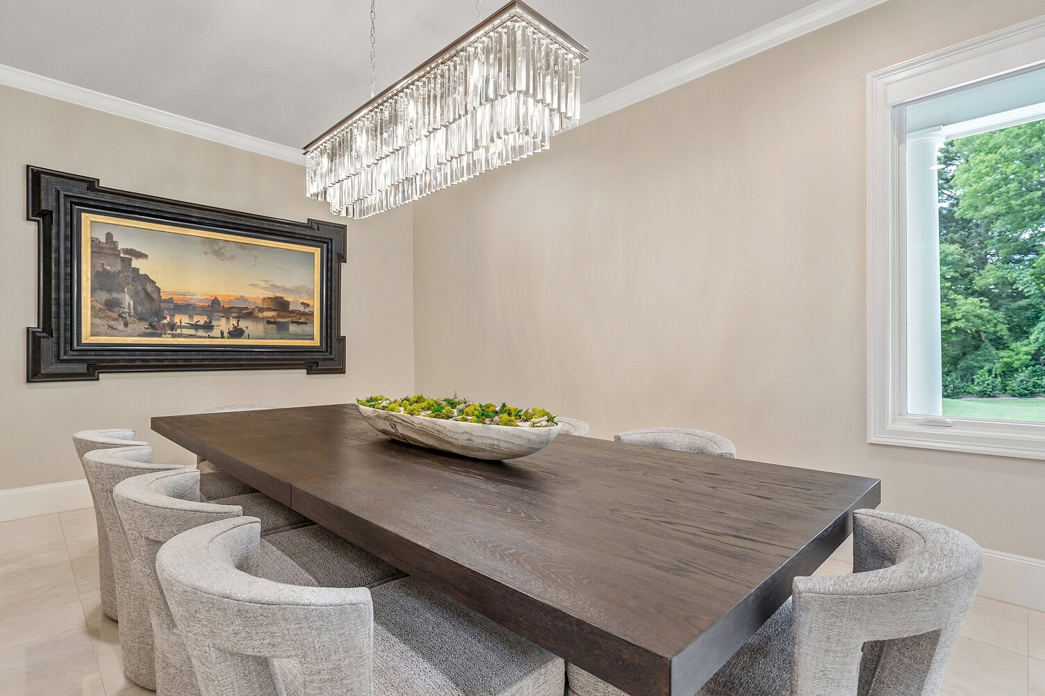 Modern dining room with a large wooden table and eight upholstered chairs.