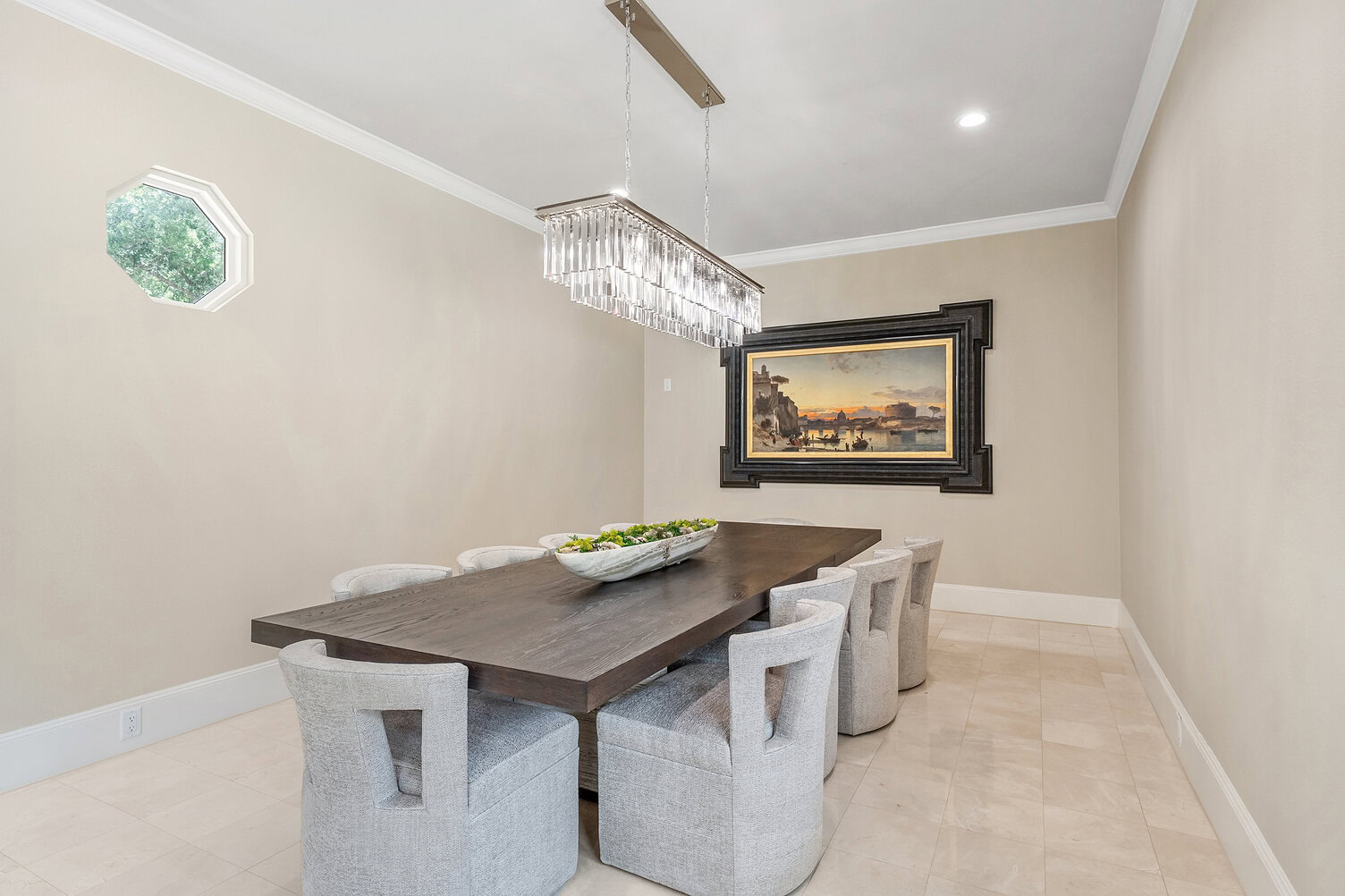 Modern dining room with a large wooden table and eight upholstered chairs.