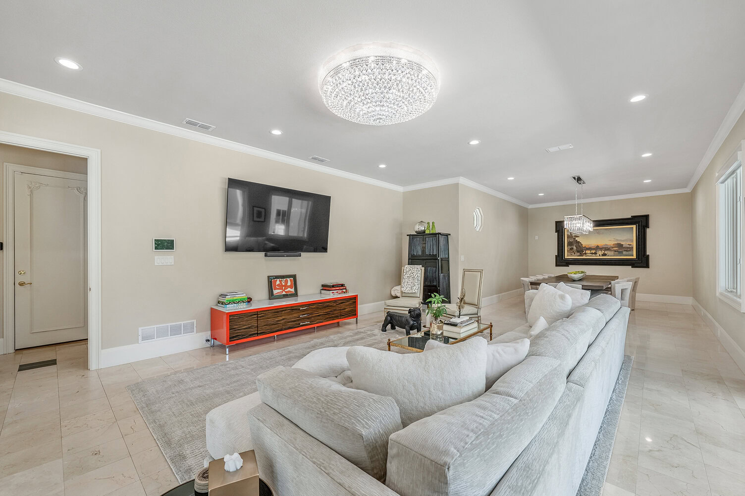 Spacious living room with modern decor and a large flat-screen TV.
