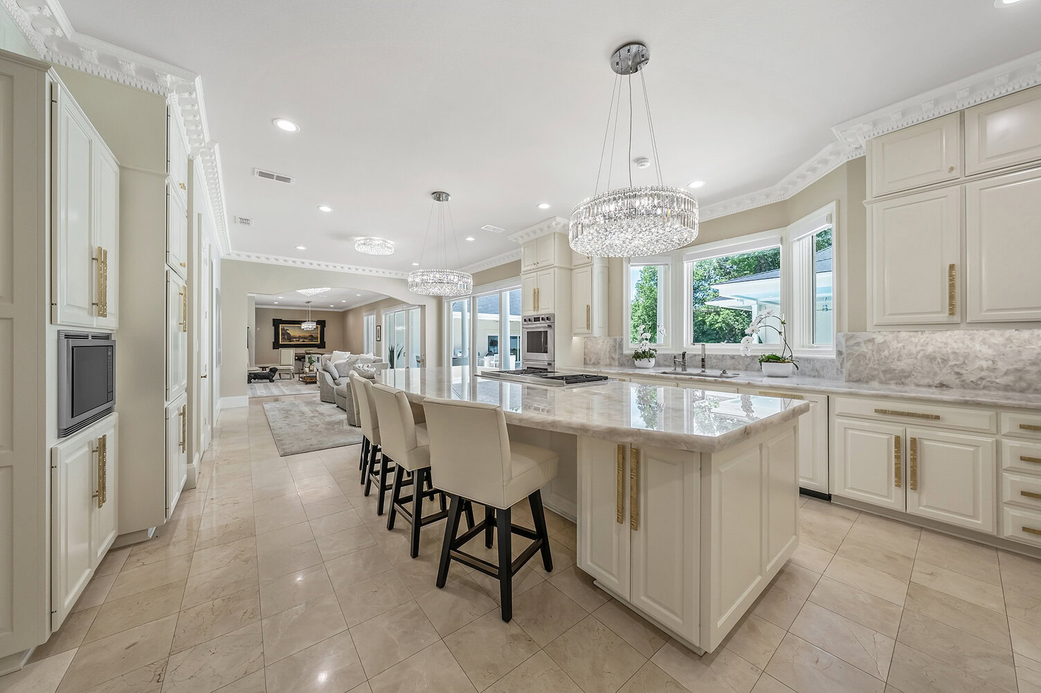 Spacious luxury kitchen with island, modern appliances, and elegant lighting fixtures.