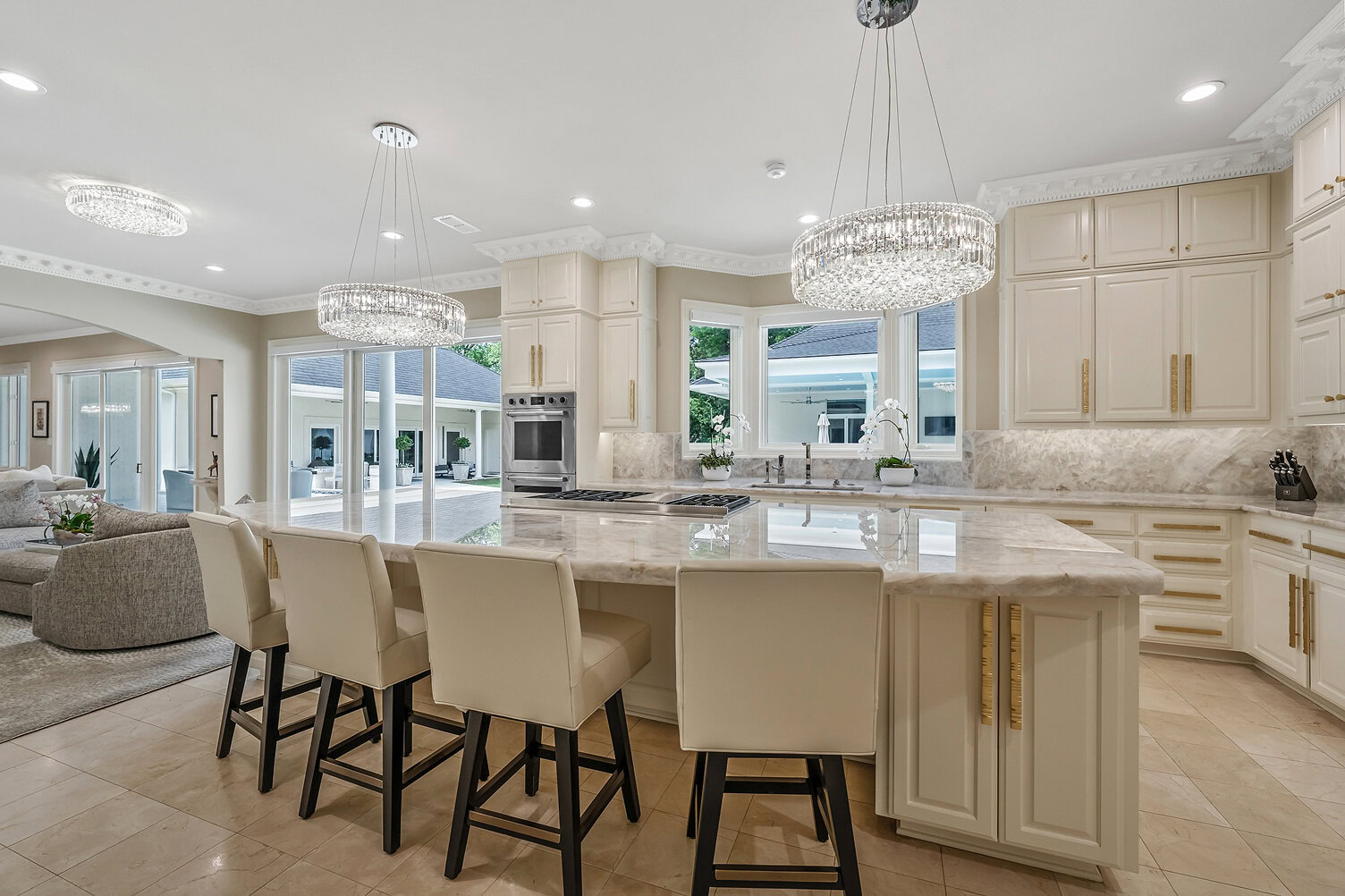 Spacious modern kitchen with white cabinets and marble countertops.
