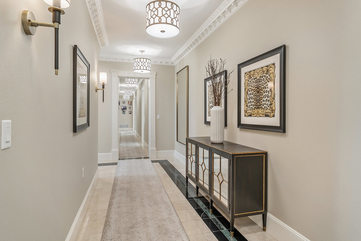 Bright, stylish hallway with artwork and modern lighting fixtures.
