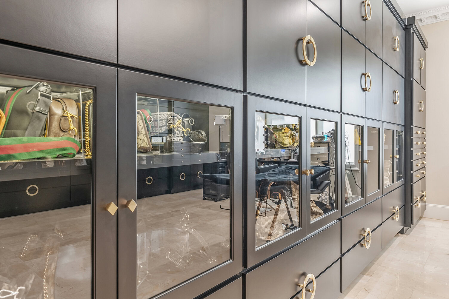 Elegant black display cabinets with glass doors showcasing designer handbags.