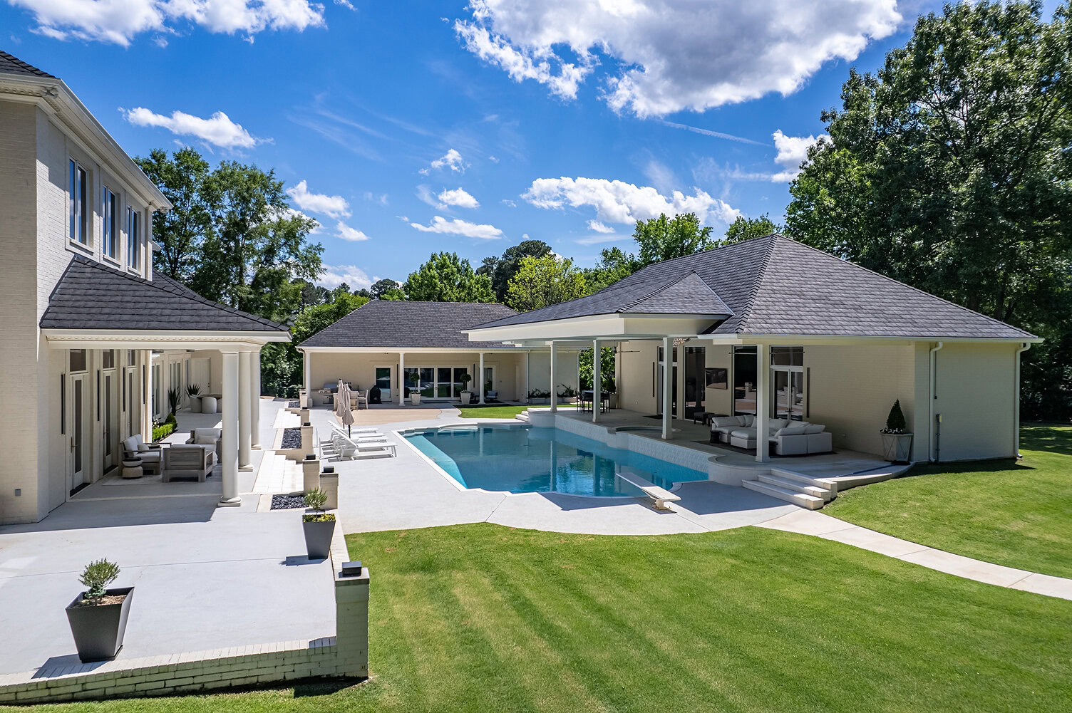 Modern backyard with swimming pool, patio, and outdoor seating area.