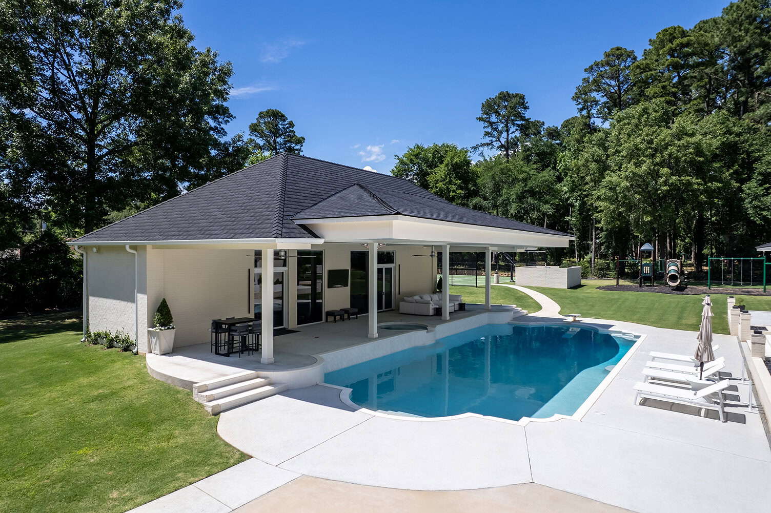 Contemporary house with a swimming pool and outdoor seating area.