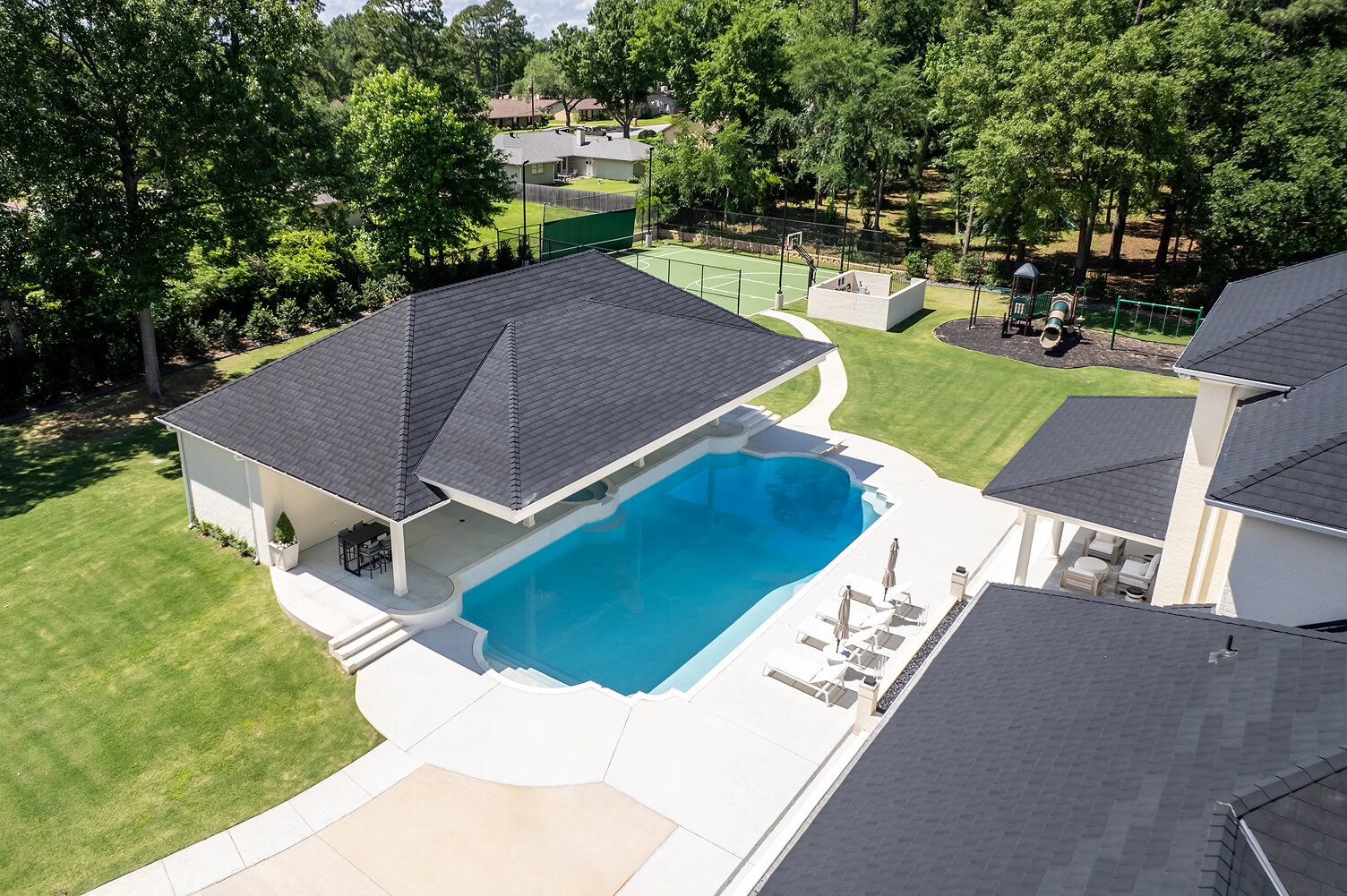 Aerial view of a modern home with a swimming pool and landscaped yard in The Thornwood.